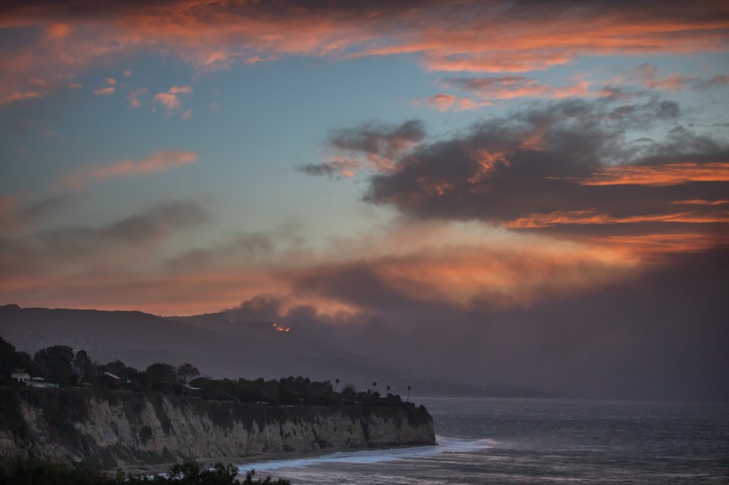 Smoke from the Palisades Fire in Malibu, California, seen from Point Dume, burning homes along the Pacific Coast Highway during a windstorm on January 8, 2025.