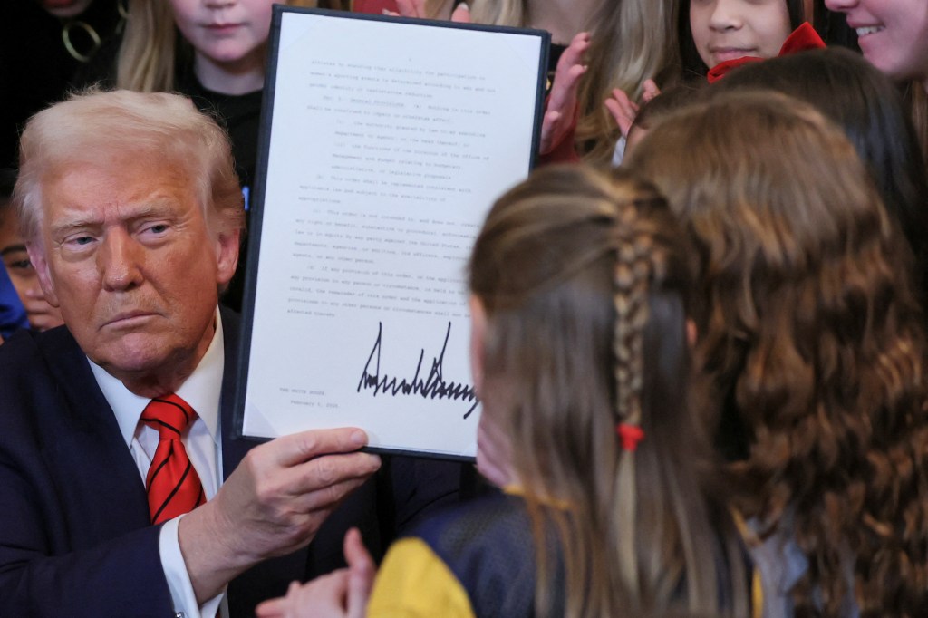 U.S. President Donald Trump holds up a signed executive order banning transgender girls and women from participating in women's sports, in the East Room at the White House in Washington, U.S., February 5, 2025. REUTERS/Leah Millis U.S. President Donald Trump signs an executive order banning transgender girls and women from participating in women's sports, at the White House