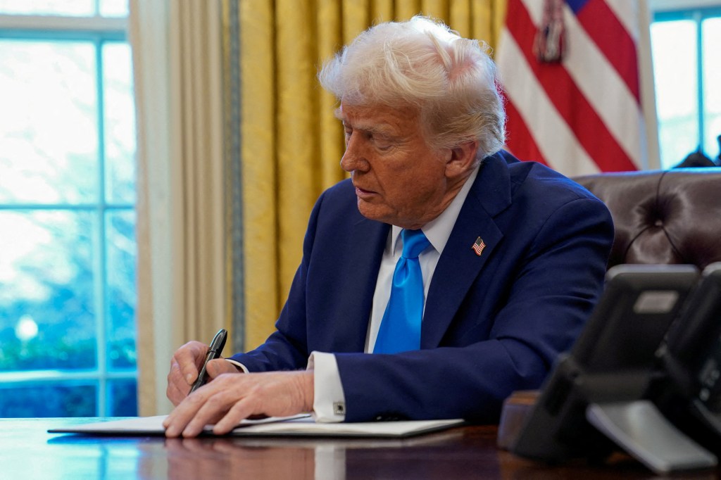 President Donald Trump signs a document in the Oval Office at the White House in Washington, U.S. February 4, 2025.