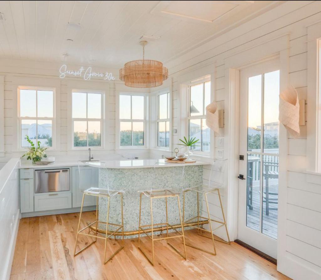 dining space of beachouse in florida with neon light sign that says sunset grove 30a 