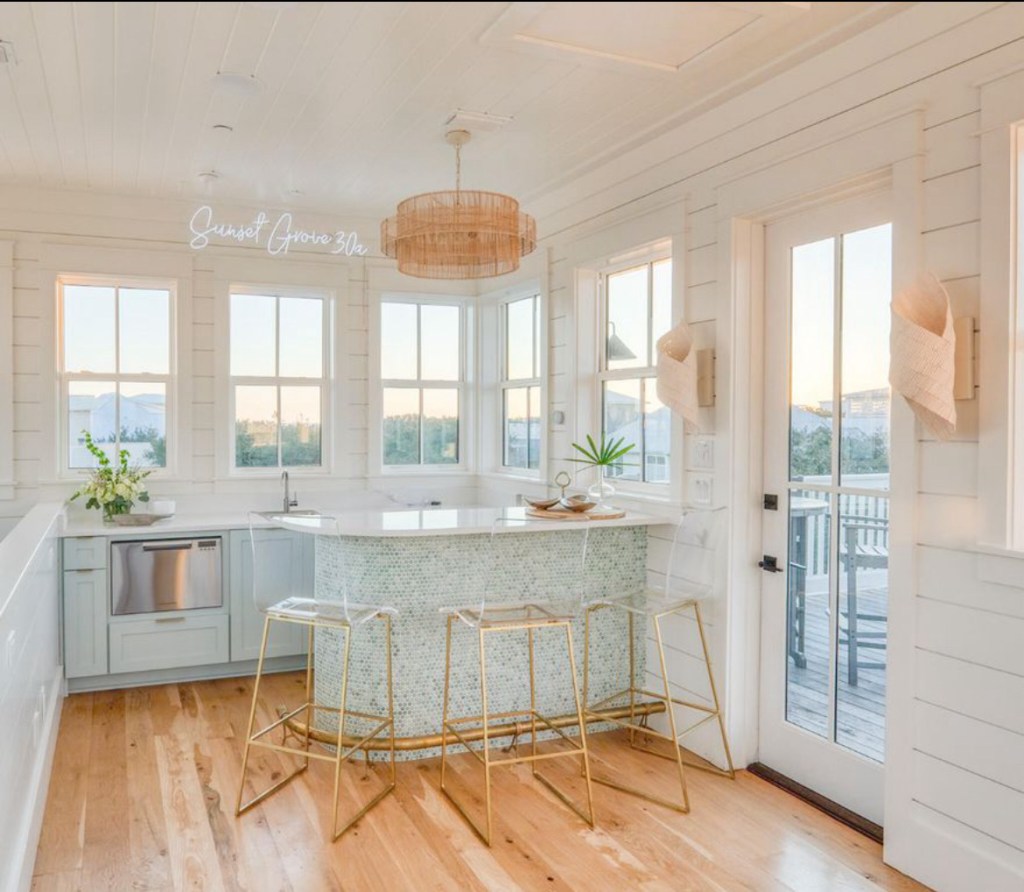 dining space of beachouse in florida with neon light sign that says sunset grove 30a 