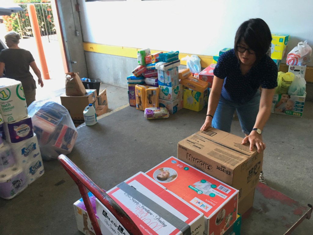Catholic Charities of the Rio Grande Valley volunteer Veronica Yoo loads boxes of donations on to a cart at a storage facility in McAllen, Texas on June 24, 2018.