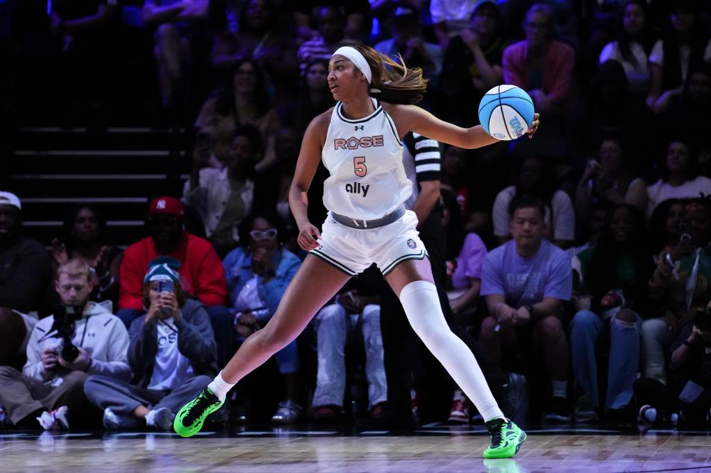 Angel Reese in basketball uniform controlling the ball against the Mist team at Wayfair Arena with a crowd watching, including several celebrities