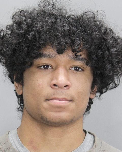 Man with curly hair dressed as Spider-Man stealing anime trading cards