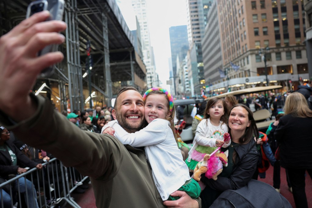 A family poses for a selfie on the day of the 264th New York City St. Patrick's Day parade in Manhattan in New York City, New York, U.S., March 17, 2025.