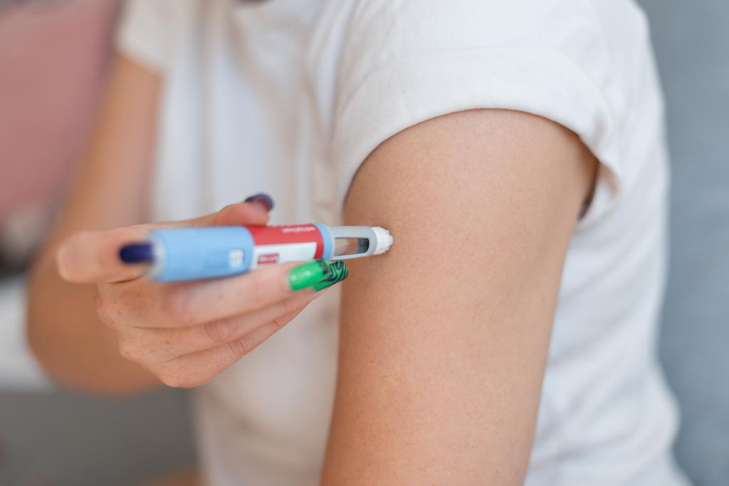 A woman injects the drug Ozempic into her arm 