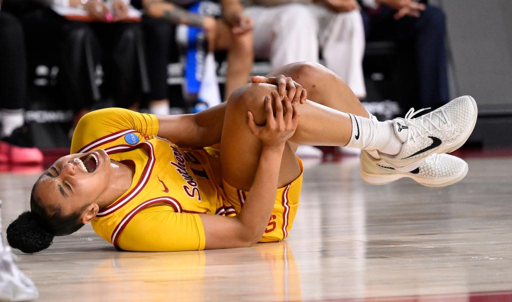 JuJu Watkins clutches her knee after getting injured during USC's March Madness game March 25.