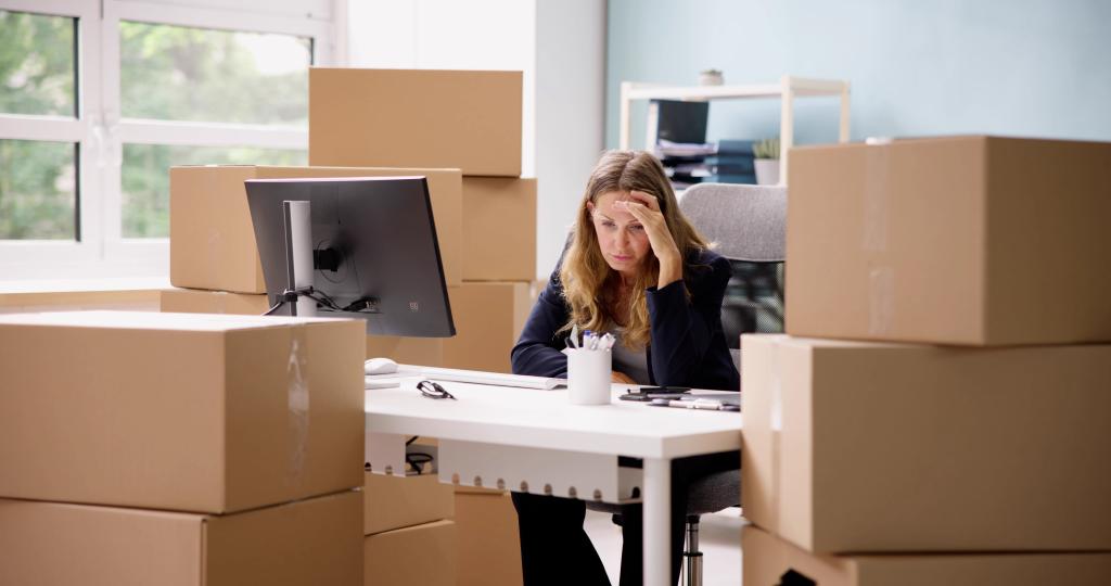 Stressed Entrepreneur working from home office with boxes around her 