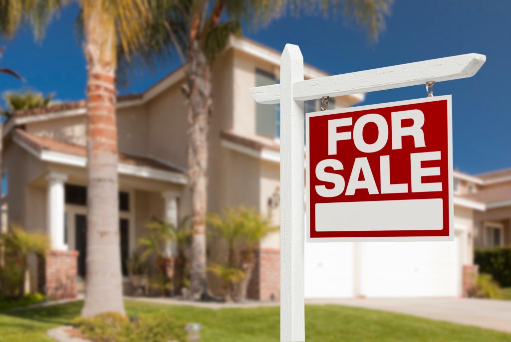 Home For Sale Real Estate Sign in Front of Beautiful New House.