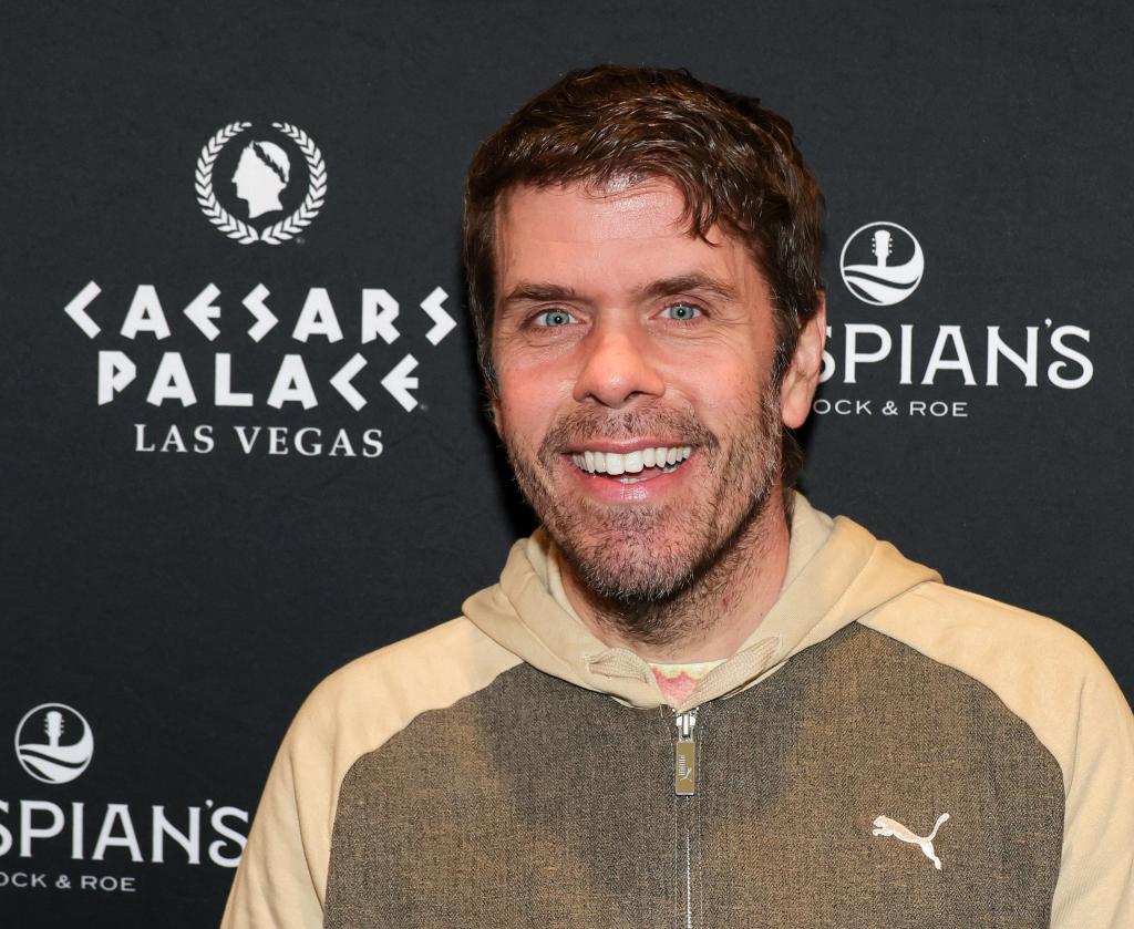 A slim Perez Hilton smiles on the runway in March 2025. 