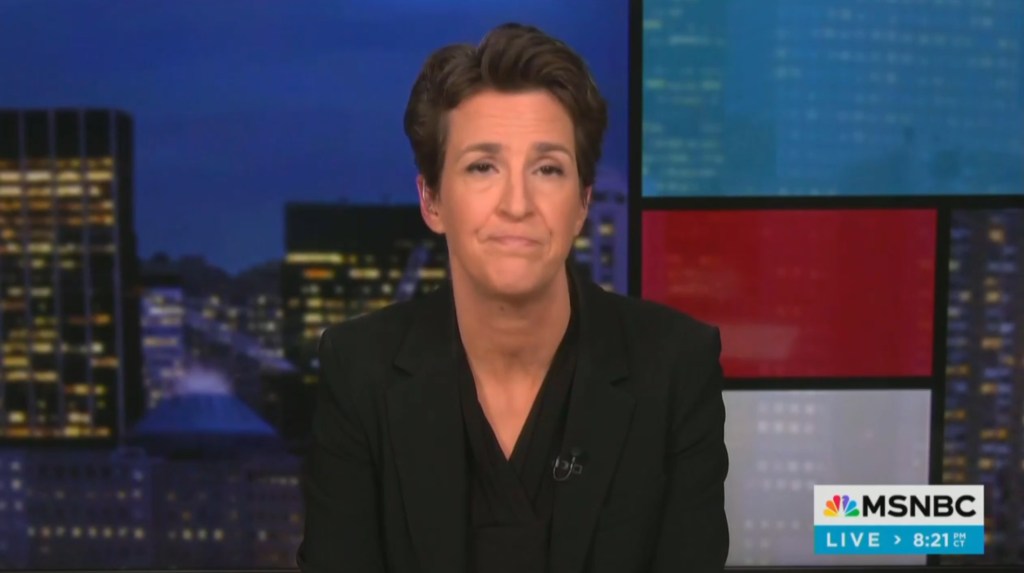 Rachel Maddow, a woman in a black suit, expressing dissatisfaction with her own network for dumping Joy Reid