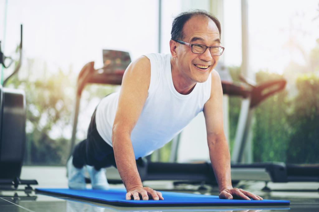 As you age, the number of push-ups you can do may decrease, but modifications can make them manageable. Here, a man does push-ups. 