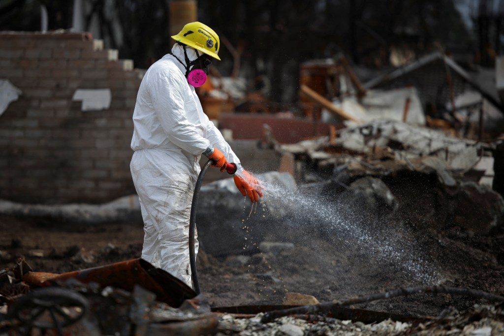 A U.S. Army Corps of Engineer contractor washes off his hand during debris removal following the Palisades Fire in the Pacific Palisades, Los Angeles, California, U.S. March 17, 2025. 