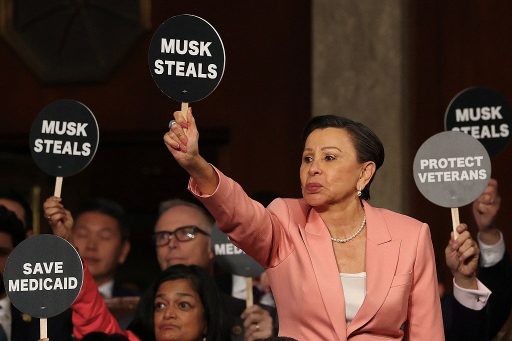 Rep. Nydia Velazquez (D-NY) holds a protest sign with fellow Democrats as U.S. President Donald Trump address a joint session of Congress at the U.S. Capitol on March 04, 2025 in Washington, DC. 