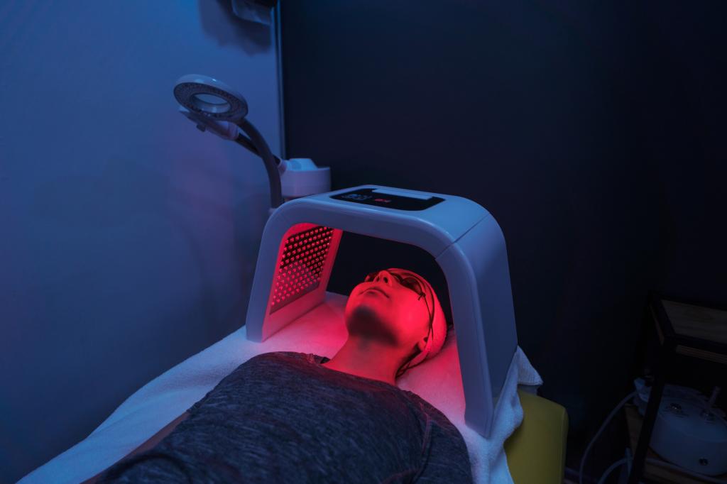 A young woman doing a red light therapy on her face.
