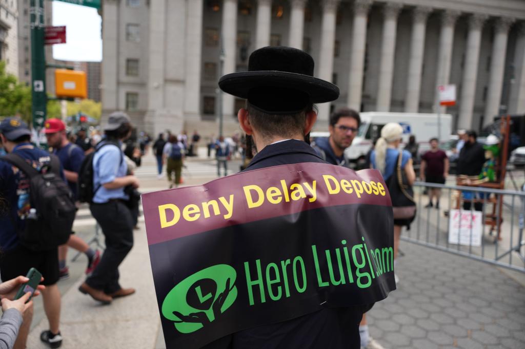 Yoel Friedman wearing a "Deny Delay Depose" sign on his back.