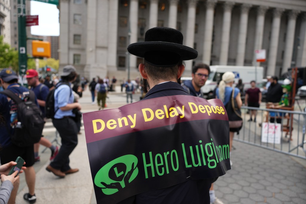 Yoel Friedman wearing a "Deny Delay Depose" sign on his back.