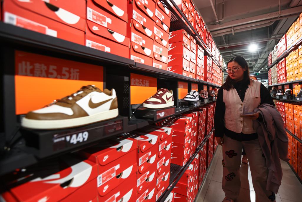 A woman examining shoes in a Nike store in Beijing, China, symbolizing the reported export growth in Q1 of 2025
