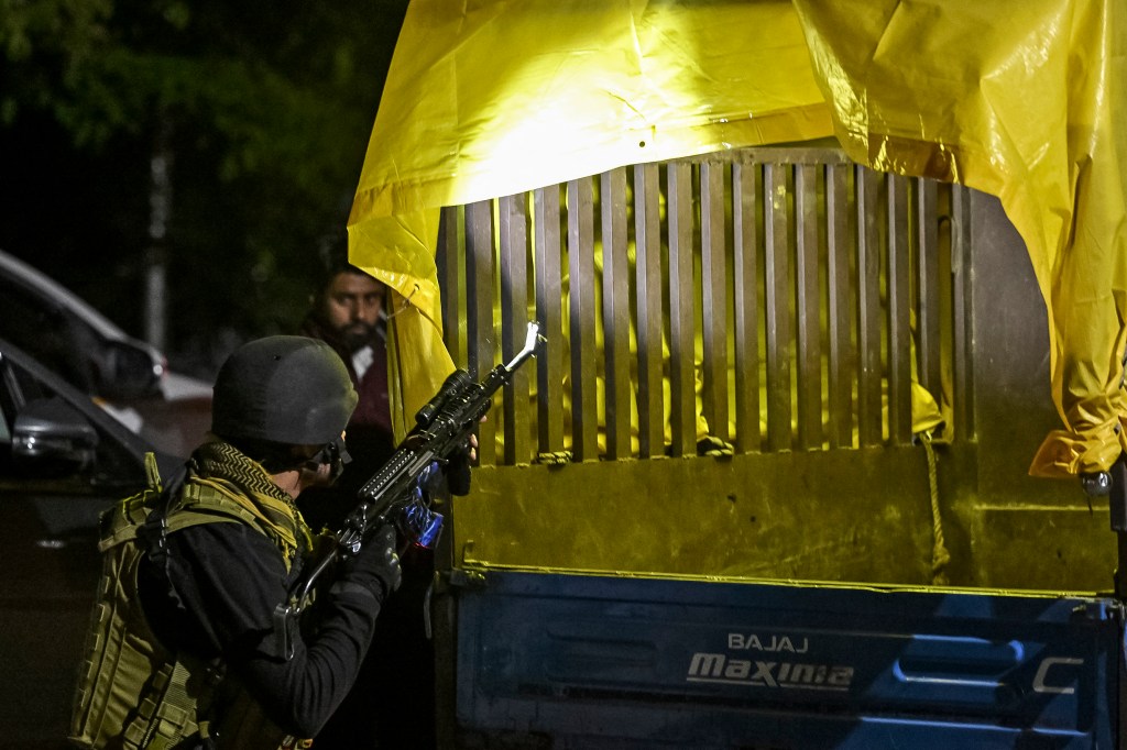 Indian Army personnel inspecting a vehicle near Pahalgam, post attack, with gun in hand