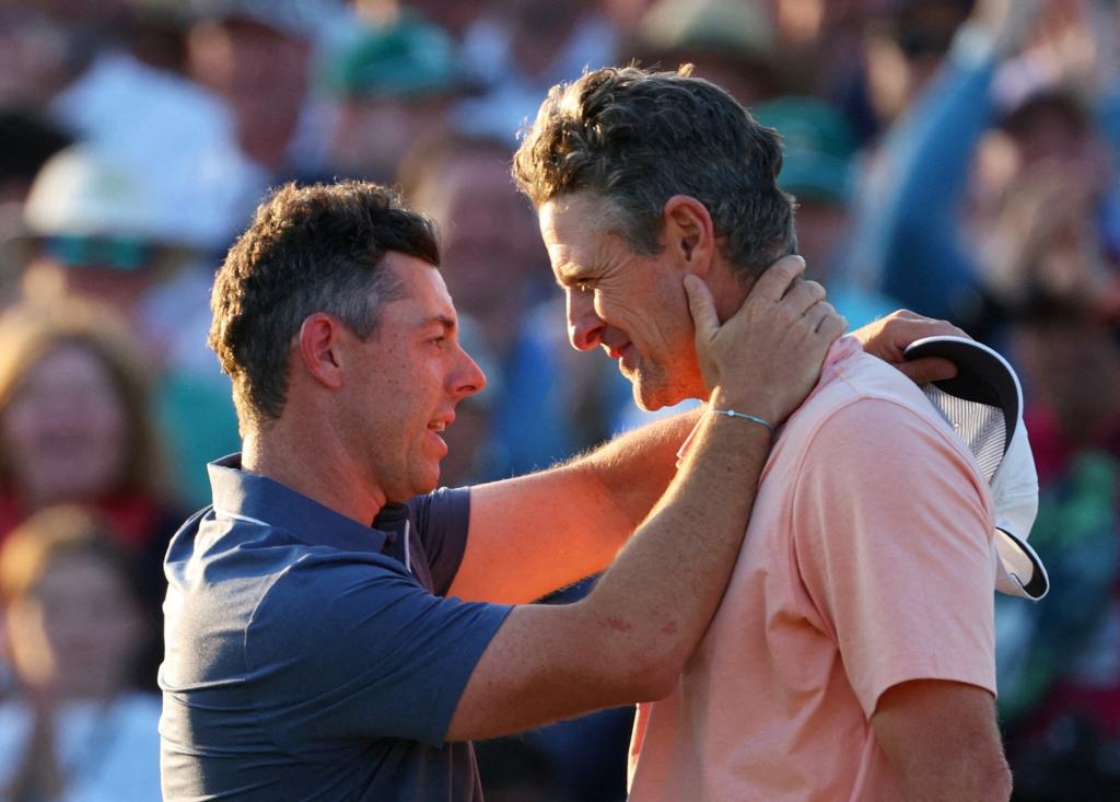 Rory McIlroy and England's Justin Rose embrace on the 18th green after McIlroy won their play-off to win The Masters and completing a career grand slam on April 13, 2025. 