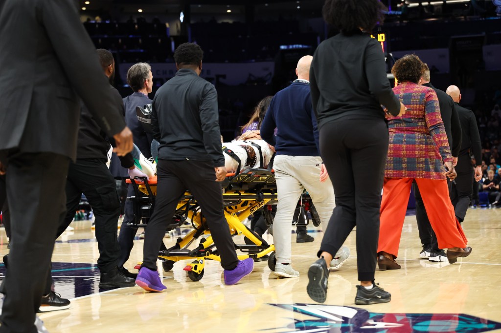 Jaylen Wells #0 of the Memphis Grizzlies is carted off the court after an injury during the first half of a basketball game against the Charlotte Hornets at Spectrum Center on April 08, 2025 in Charlotte, North Carolina. 