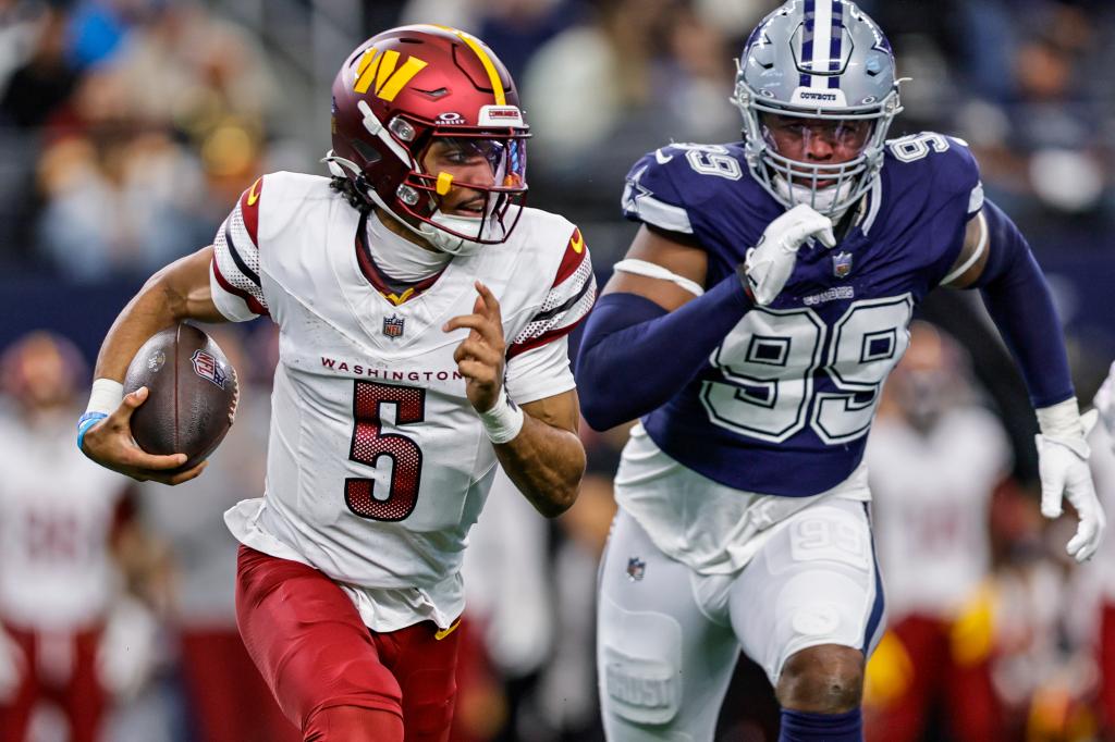 Washington Commanders quarterback Jayden Daniels (5) runs a quarterback keeper chase by Dallas Cowboys defensive end Chauncey Golston (99) during the game between the Dallas Cowboys and the Washington Commanders on January 5, 2025 at AT&T Stadium in Arlington, Texas. 
