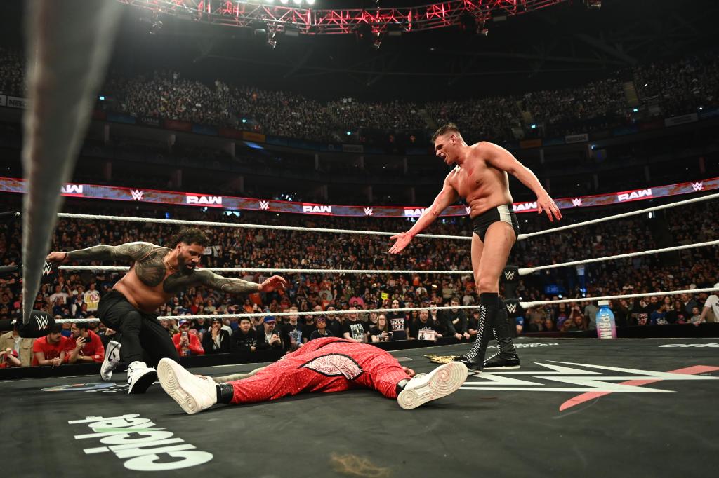 Gunther (r.) stands over Jimmy Uso (c.) with Jey Uso (l.) tied to the rope during Raw on March 31, 2025.