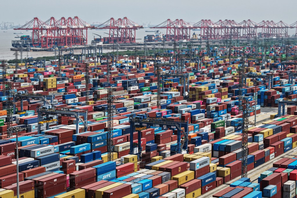 Aerial view shows cargo containers stacked at a port in Shanghai on April 20, 2025.