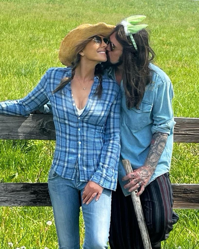 Billy Ray Cyrus kissing Elizabeth Hurley near a fence