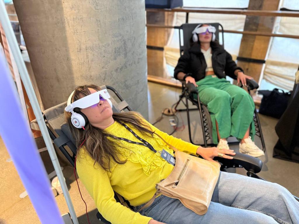 The BrainTap Headset consists of an LED visor and headphones that play binaural beats and isochronic tones to promote relaxation. Here, two women test it at the conference.
