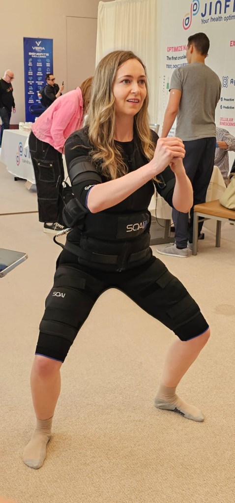 The SQAI Power Suit (pictured here) sends electrical impulses to muscles. Here, a woman squats as she wears it.