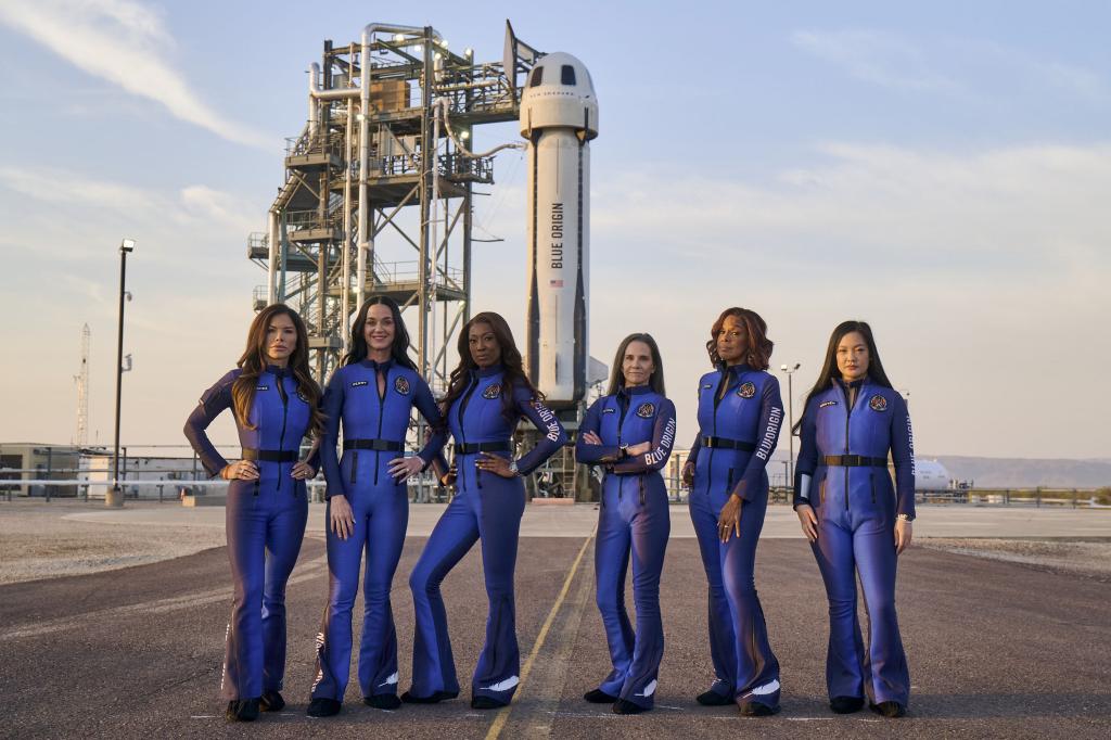 All-female crew including Lauren Sanchez, Katy Perry, Aisha Bowe, Kerianne Flynn, Gayle King, Amanda Nguyen in blue jumpsuits in front of Blue Origin's New Shepard rocket ahead of space launch