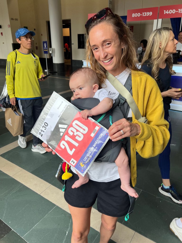 Natalie Daniels and her son Cooper, pick up her race bib for the Boston Marathon.
