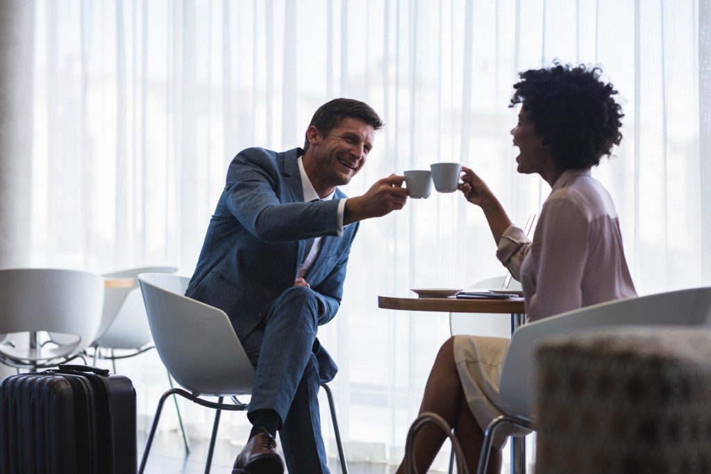 Coffee may get your flight off to a rough start. Here, two people toast with coffee at the airport.