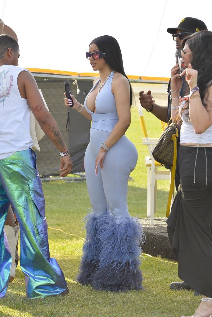 Cardi B in stylish outfit beating the heat, surrounded by fans and cameras at Coachella Weekend 1