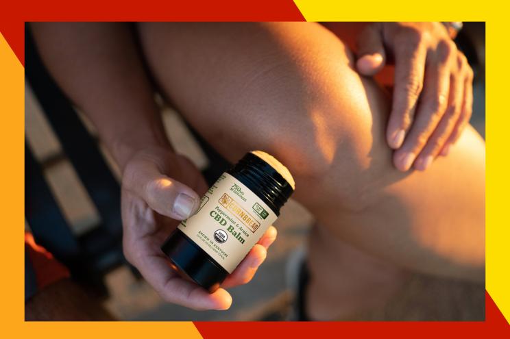 A person holding a bottle of CBD oil
