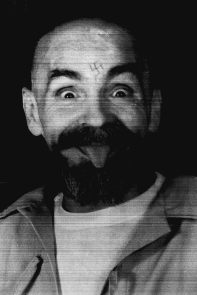 Charles Manson clowns around as he is led to his cell upon the conclusion of his exclusive interview with Reuters August 25, 1989.
