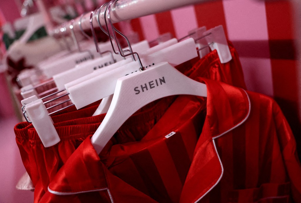 Shein company logo displayed on a rail of clothing on a Christmas promotional bus in Liverpool, Britain