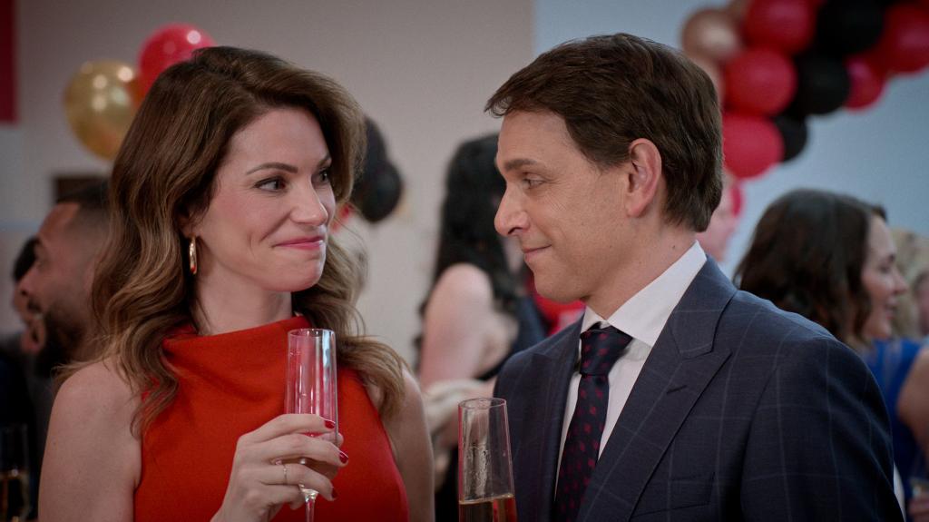 Courtney Henggeler as Amanda LaRusso and Ralph Macchio as Daniel LaRusso in "Cobra Kai," holding champagne glasses
