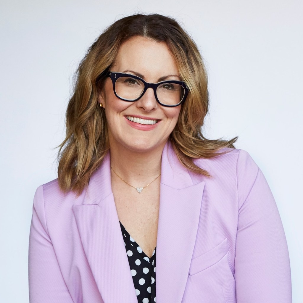 Dr. Staci Whitman in a pink jacket and glasses