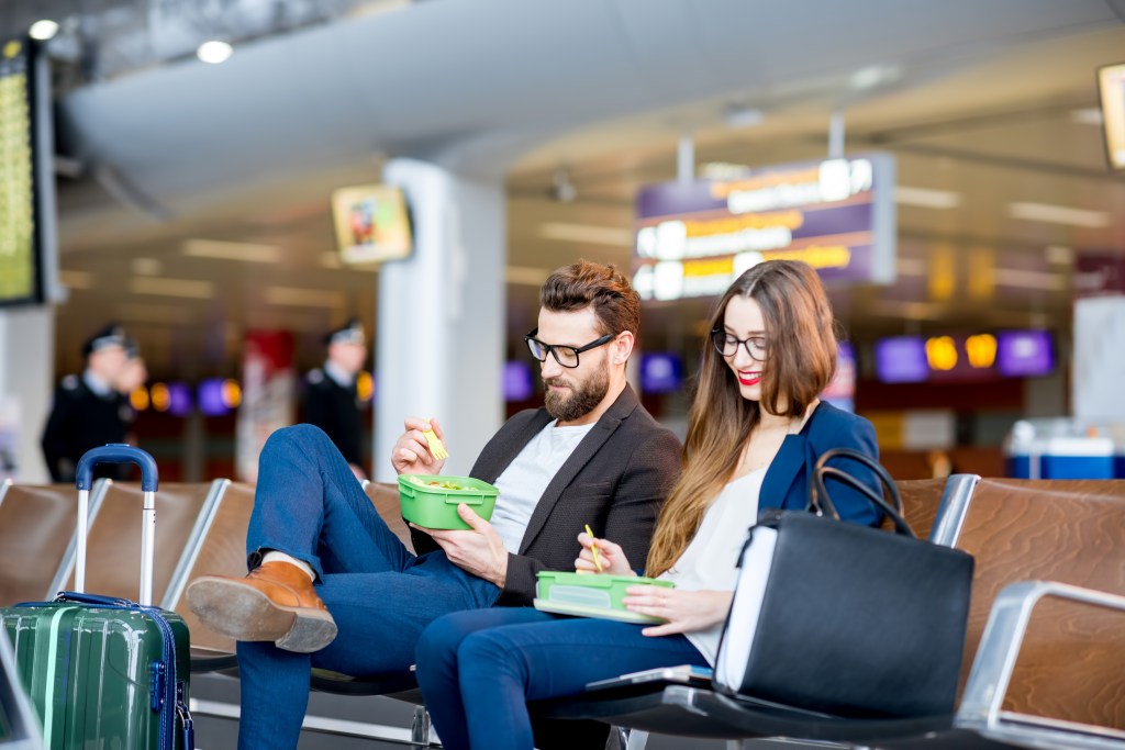 It's not just coffee beans to worry about. One registered dietitian nutritionist warns of consuming beans at the airport. Here, a young couple eats from lunch boxes at the airport.