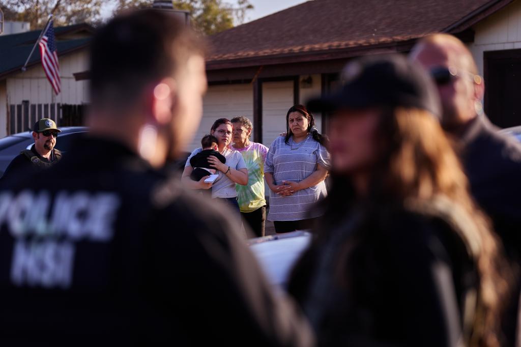 Family members watch as United States Department of Homeland Security Secretary Kristi Noem accompanied a multi-agency law enforcement raid in the apprehension of Jose Escobar-Robles, who is suspected of money laundering for a Mexican cartel, on Tuesday, April 8, 2025 in Phoenix, Ariz.