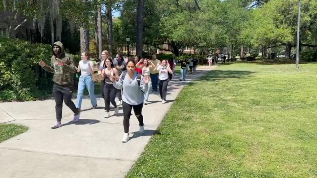 Florida State students being moved from an area near the union with their hands above their head. 