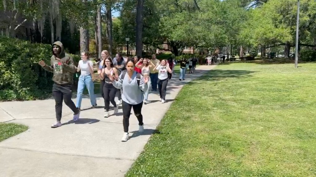 Florida State students being moved from an area near the union with their hands above their head. 