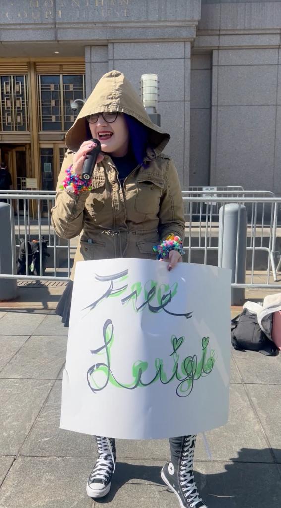 Chaos V, a singer holding a "Free Luigi" sign.