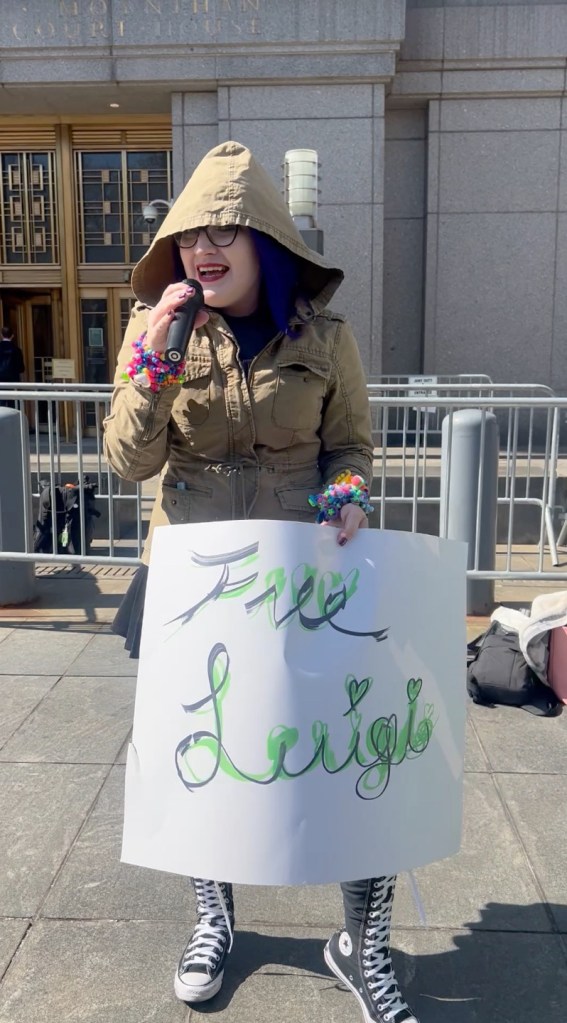 Chaos V, a singer holding a "Free Luigi" sign.