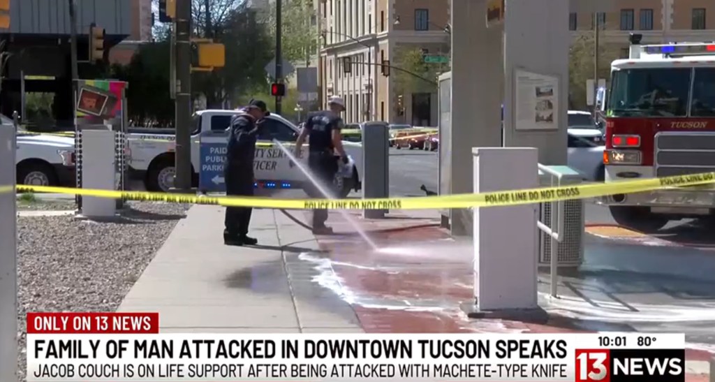 Officials clean off the bus stop where the bloody attack took place in downtown Tuscon, Arizona, on April 5, 2025.