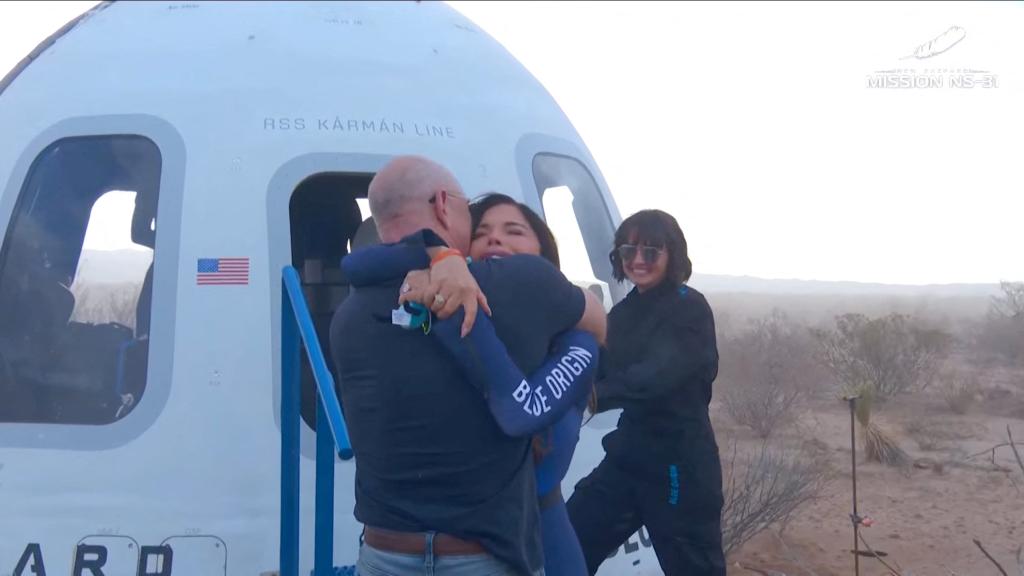 Jeff Bezos embraces Lauren Sanchez as she comes out of the capsule
