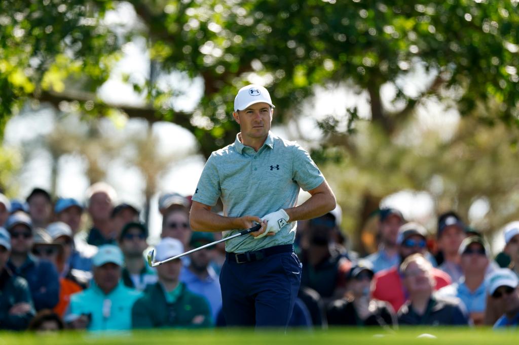 Jordan Spieth in a white hat and grey shirt playing a shot from the fourth tee during the third round of the 2025 Masters Tournament at Augusta National Golf Club