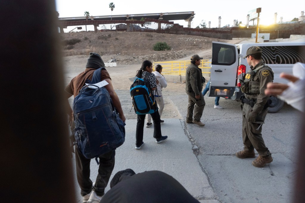 Migrants make board a van after illegally crossing into the US and waiting to apply for asylum on Jan. 21, 2025.